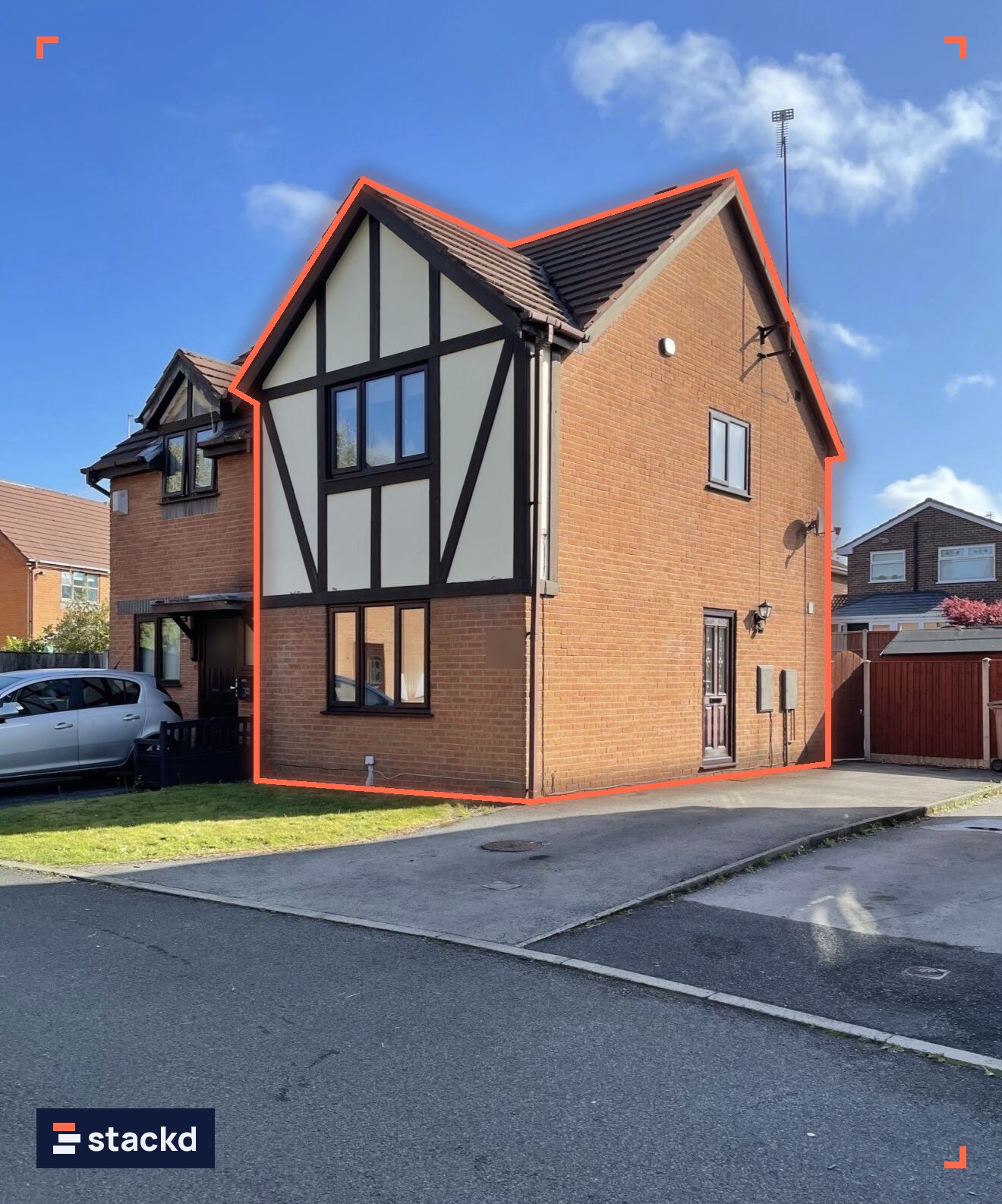 Semi-detached brick house with a mock-Tudor first-floor facade on a sunny day